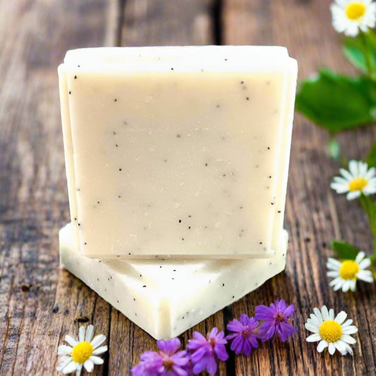 Stack of soap bars with natural elements like rocks and plants in the background
